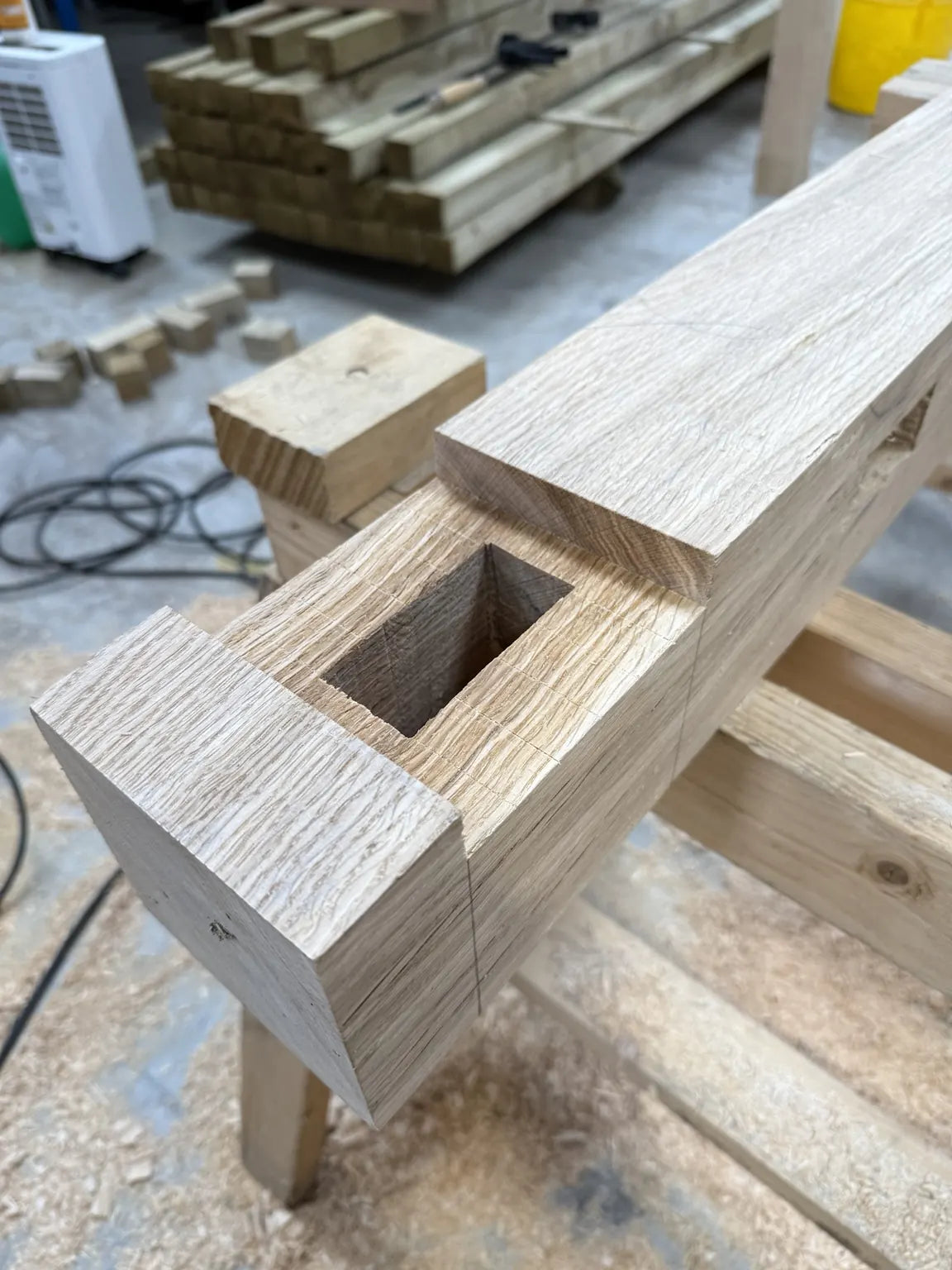 Freshly cut mortise in an oak beam on a workshop bench