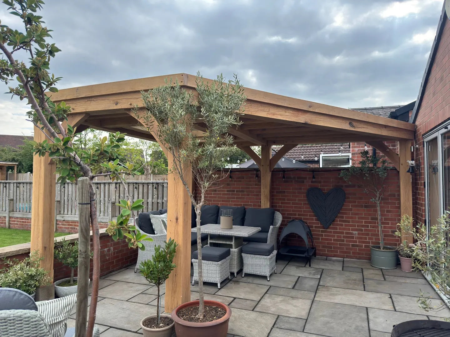 Bespoke oak frame with a roof over a garden seating area
