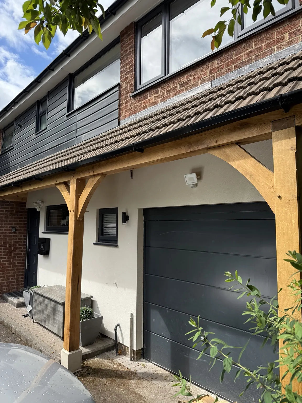 Oak porch frame with curved braces beside a house entrance